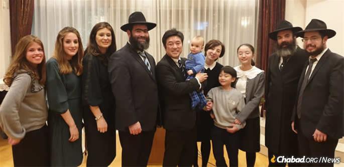 Japan's State Minister for Foreign Affairs Yasuhide Nakayama and family with Chabad of Japan emissaries at a Chanukah event last month at the Israeli embassy in Tokyo. L to R, Rachel Vaisfiche, Batya Vishedsky, Chana Sudakevich, Rabbi Shmuel Vishedsky, the Nakayamas, Rabbi Mendi Sudakevich, Rabbi Shalom Vaisfiche.